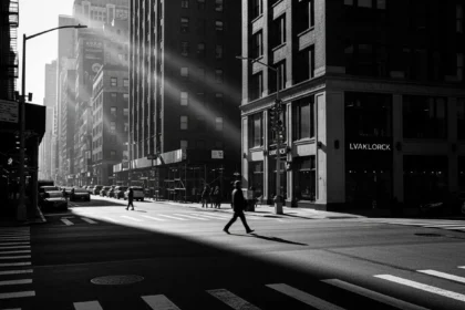 Cena de fotografia de rua com pedestre atravessando faixa de luz entre construções